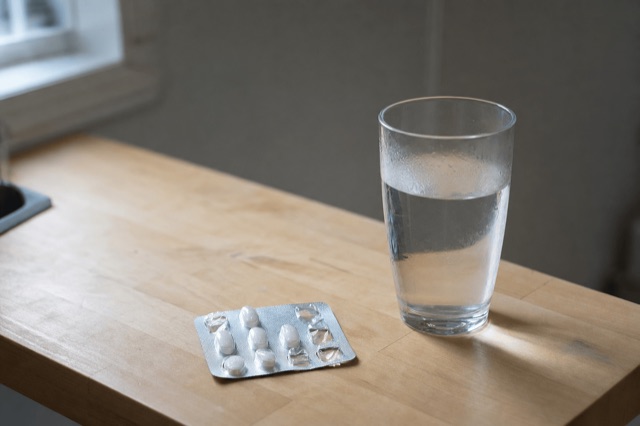 A blister pack of small prescription tablets resting on a kitchen counter in soft daylight