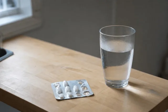 A blister pack of small prescription tablets resting on a kitchen counter in soft daylight