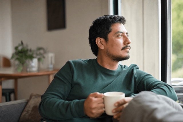 A person sitting quietly by a sunlit window, looking calm and reflective during a moment of acceptance