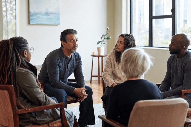 A small outpatient therapy group meeting in a calm, sunlit room near Boston