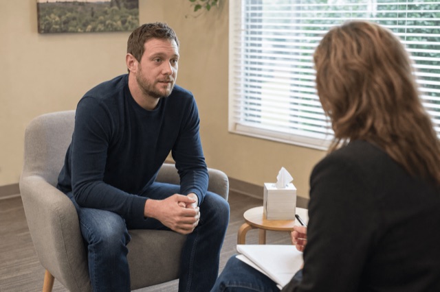 A person in a calm clinic consultation room talking with a clinician about opioid treatment options
