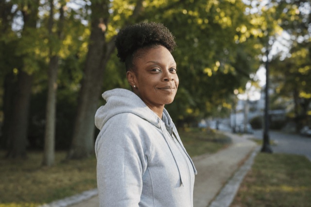 A person standing outdoors in soft morning light, looking calm and reflective during recovery
